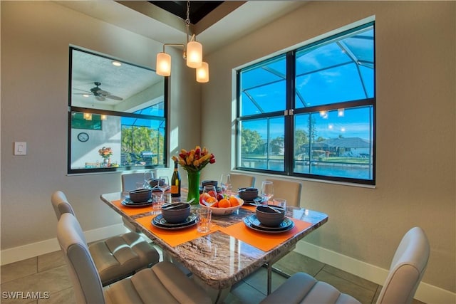 tiled dining room with baseboards and ceiling fan