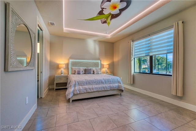 bedroom featuring a tray ceiling and baseboards