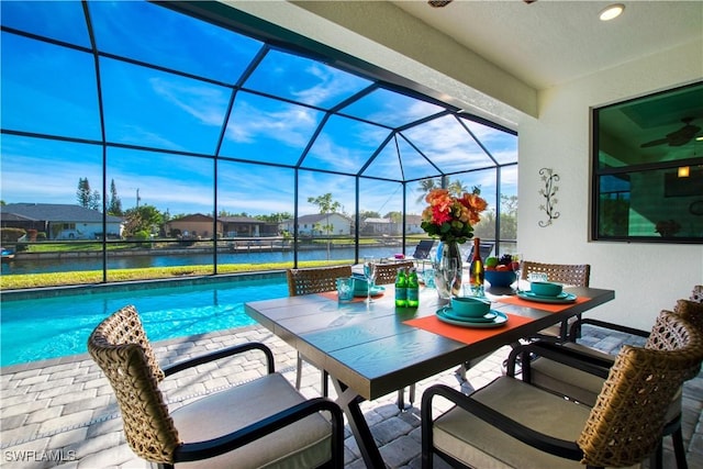 view of patio / terrace featuring an outdoor pool, a lanai, a water view, outdoor dining area, and a residential view