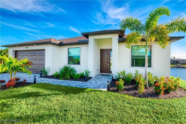 view of front of house featuring an attached garage, a front yard, and stucco siding