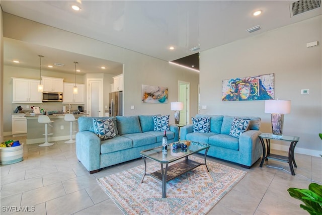 living room featuring light tile patterned floors, recessed lighting, and baseboards