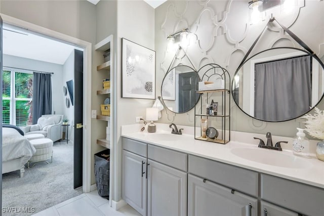 ensuite bathroom with double vanity and tile patterned flooring