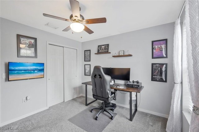 carpeted office featuring a ceiling fan and baseboards