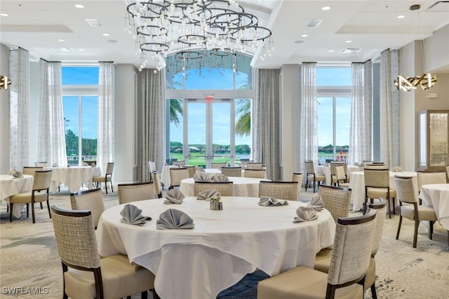 dining room featuring a high ceiling, healthy amount of natural light, a chandelier, and recessed lighting