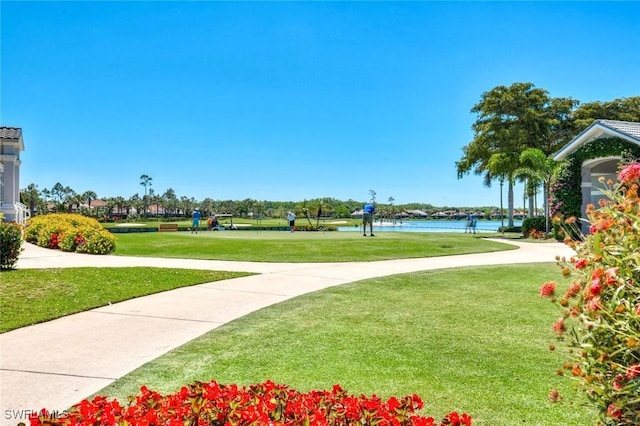 surrounding community with a lawn and a water view