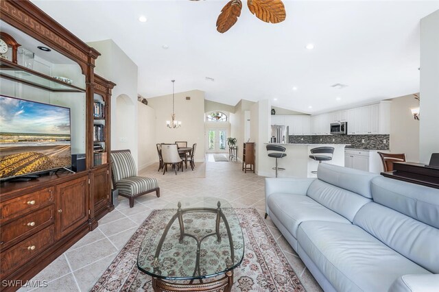 living area with vaulted ceiling, a chandelier, light tile patterned floors, and recessed lighting