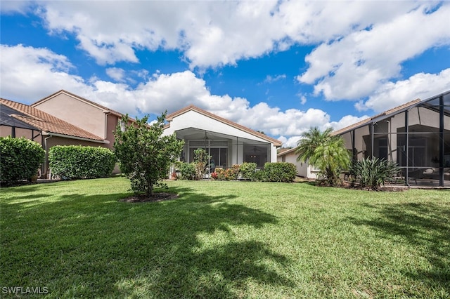 view of grassy yard with a lanai