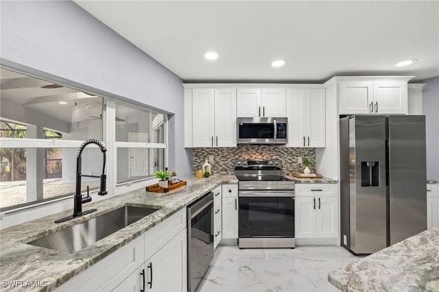 12721 Kelly Sands Way, Fort Myers, FL 33908 - kitchen featuring stainless steel appliances, a sink, light marble finish floors, tasteful backsplash, and light stone countertops