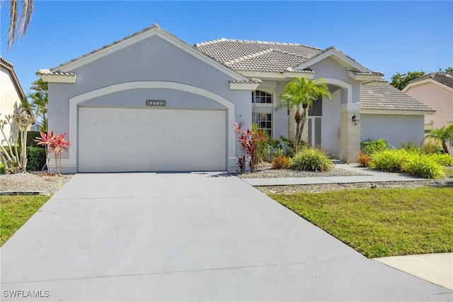12721 Kelly Sands Way, Fort Myers, FL 33908 - mediterranean / spanish home featuring a tiled roof, a garage, driveway, and stucco siding