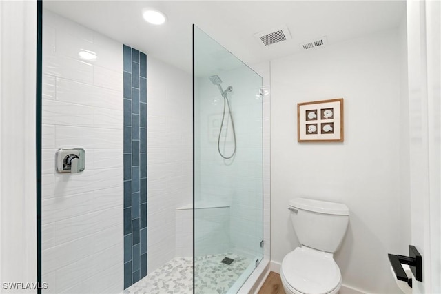 full bath with tiled shower, toilet, and baseboards