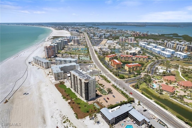 view of urban area featuring waterfront with a beach