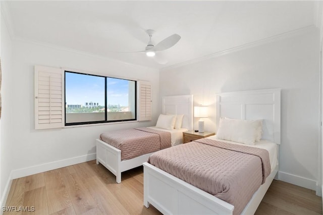 bedroom featuring ornamental molding, light wood-style floors, baseboards, and a ceiling fan