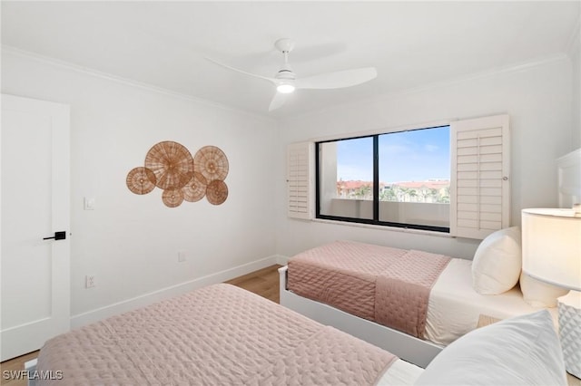 bedroom with crown molding, baseboards, a ceiling fan, and wood finished floors