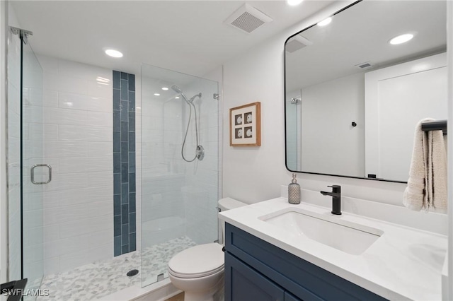 bathroom with toilet, a stall shower, recessed lighting, and vanity