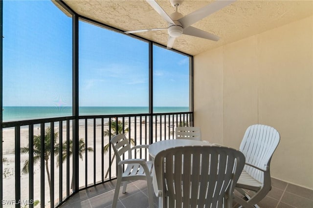 sunroom / solarium featuring view of water and beach
