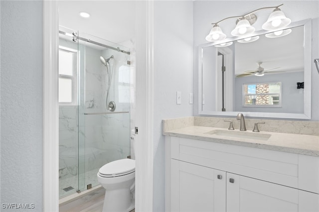 full bathroom featuring a marble finish shower, toilet, vanity, and a ceiling fan