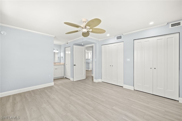 unfurnished bedroom with crown molding, multiple closets, baseboards, recessed lighting, and light wood-style floors