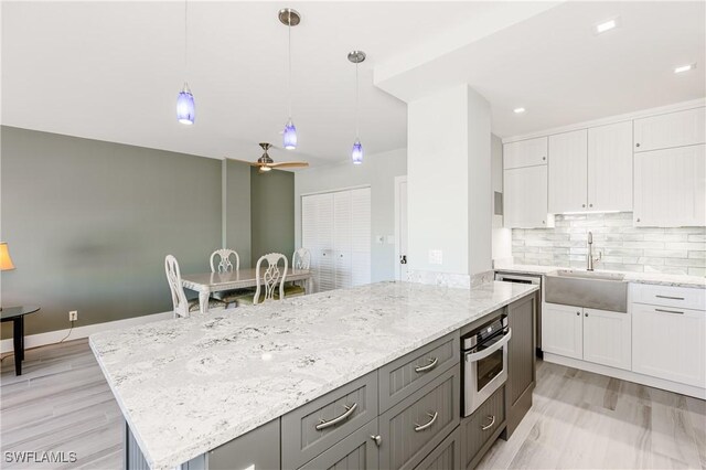 500 Saturn Ct Unit 48, Marco Island, FL 34145 - kitchen featuring a sink, stainless steel oven, white cabinets, and light stone counters