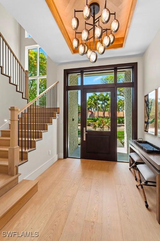 entrance foyer with stairs, wood finished floors, and baseboards