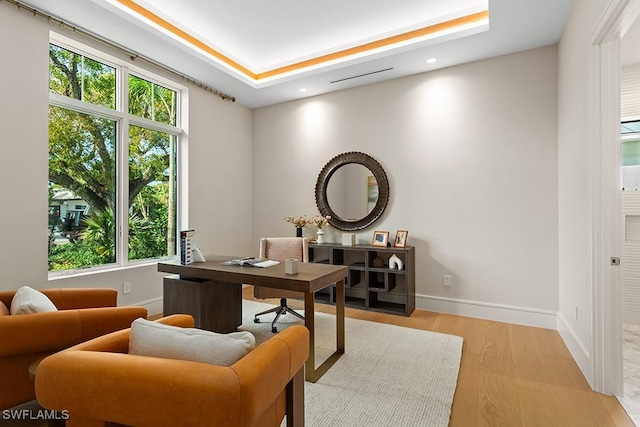 home office with healthy amount of natural light, recessed lighting, light wood-style flooring, and baseboards