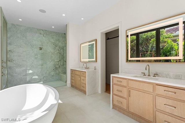 bathroom featuring two vanities, a soaking tub, walk in shower, and recessed lighting