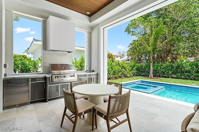 view of pool with exterior kitchen, a grill, a patio, a sink, and outdoor dining space