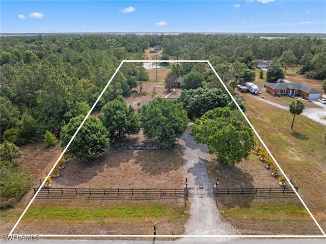 aerial view of sparsely populated area with property parcel outlined and a forest
