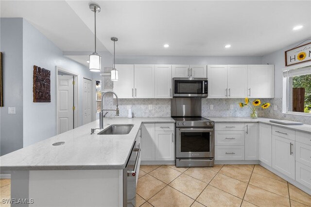 kitchen featuring stainless steel appliances, a sink, a peninsula, white cabinets, and tasteful backsplash