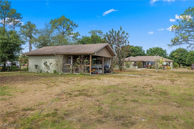 back of house with a carport and a yard