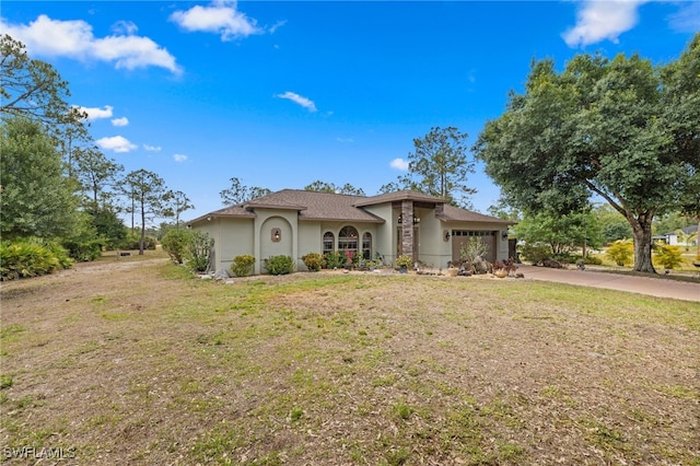 mediterranean / spanish house with stucco siding, an attached garage, concrete driveway, and a front yard