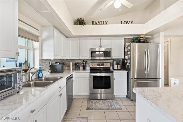927 NW 12th Ter, Cape Coral, FL 33993 - kitchen with appliances with stainless steel finishes, a sink, white cabinetry, and vaulted ceiling