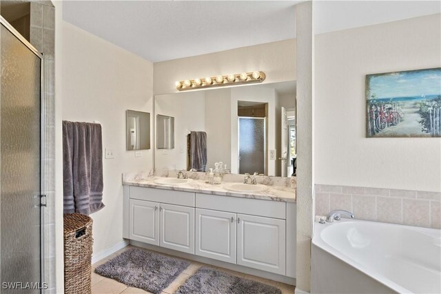 927 NW 12th Ter, Cape Coral, FL 33993 - bathroom featuring a shower stall, a bath, double vanity, and tile patterned floors