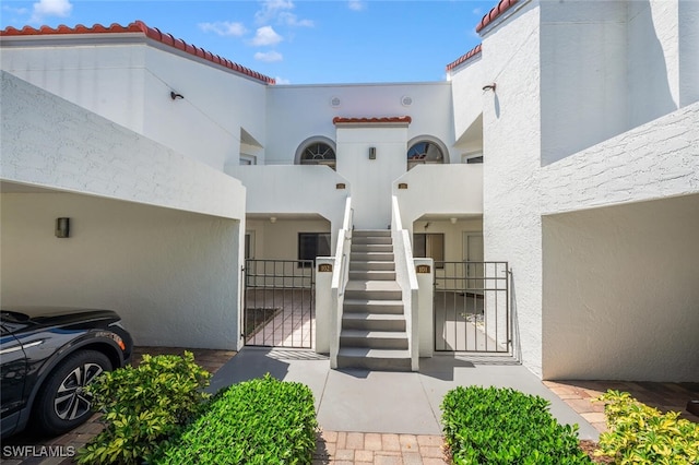 entrance to property featuring a gate, stucco siding, and a tiled roof