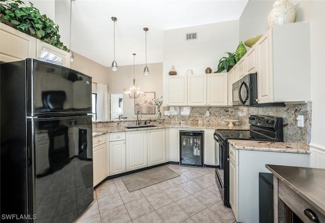 kitchen with black appliances, wine cooler, a sink, a chandelier, and backsplash