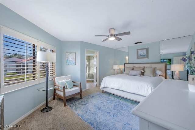 bedroom with carpet flooring, baseboards, ensuite bathroom, and a ceiling fan