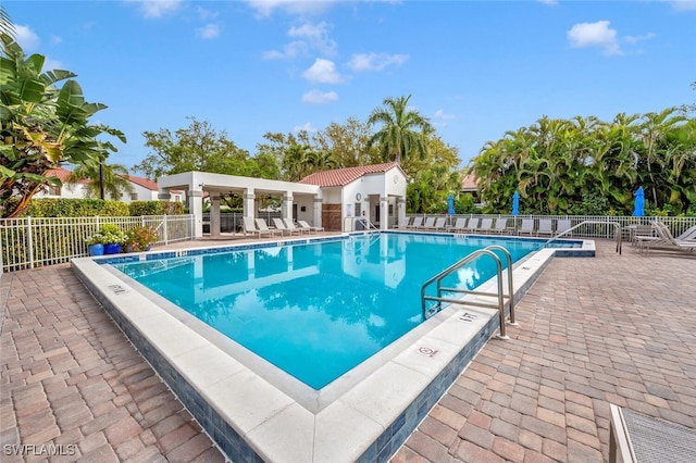 community pool with fence and a patio