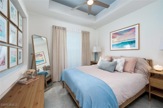 bedroom with a tray ceiling and a ceiling fan