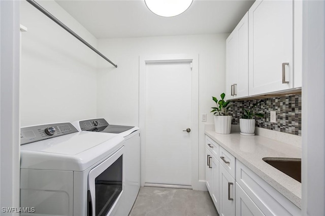 laundry room featuring separate washer and dryer and cabinet space