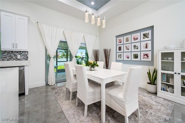dining area featuring a chandelier and baseboards