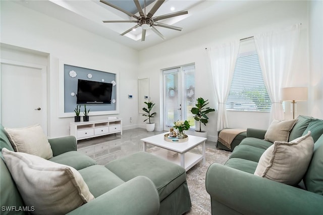 living room with a ceiling fan and baseboards