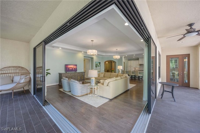 2745 Tiburon Blvd E Unit 102, Naples, FL 34109 - living room featuring dark wood-type flooring, crown molding, ceiling fan, a textured ceiling, and a tray ceiling
