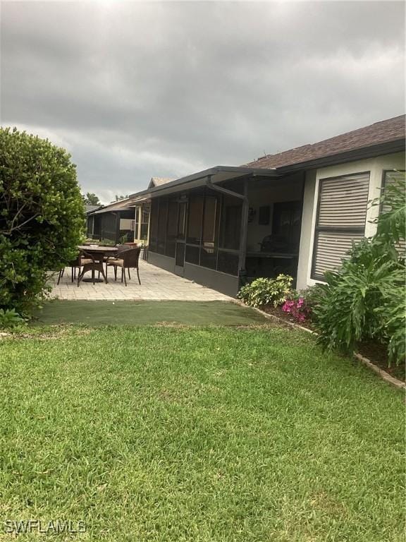 6721 Southwell Dr, Fort Myers, FL 33966 - view of green lawn with a sunroom and a patio