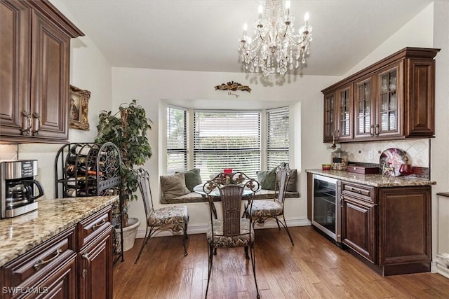 6721 Southwell Dr, Fort Myers, FL 33966 - kitchen featuring wine cooler, light stone counters, wood-type flooring, and tasteful backsplash