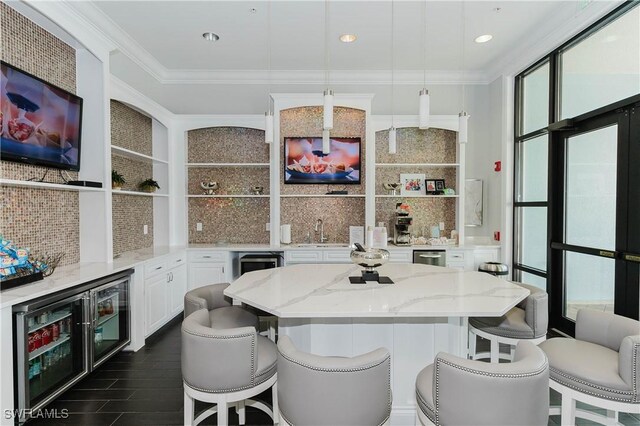 6138 Triumph Ln, Ave Maria, FL 34142 - kitchen with open shelves, white cabinets, decorative backsplash, light stone countertops, and ornamental molding