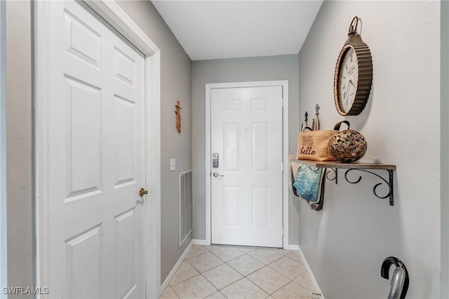doorway to outside featuring light tile patterned floors and baseboards