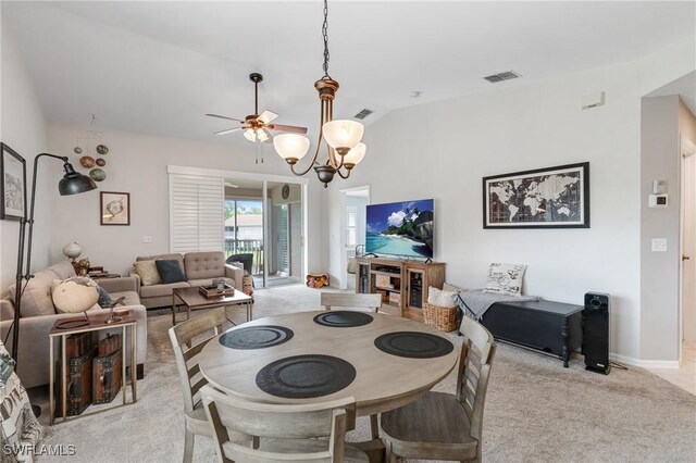 carpeted dining area featuring ceiling fan, vaulted ceiling, and a chandelier