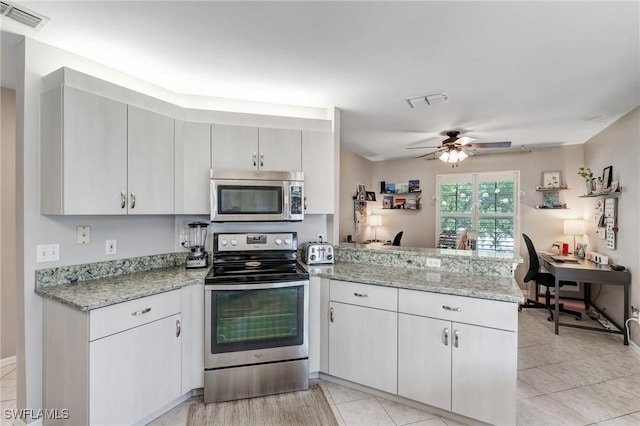 14560 Daffodil Dr Unit 905, Fort Myers, FL 33919 - kitchen featuring stainless steel appliances, a peninsula, a ceiling fan, a desk, and light stone countertops