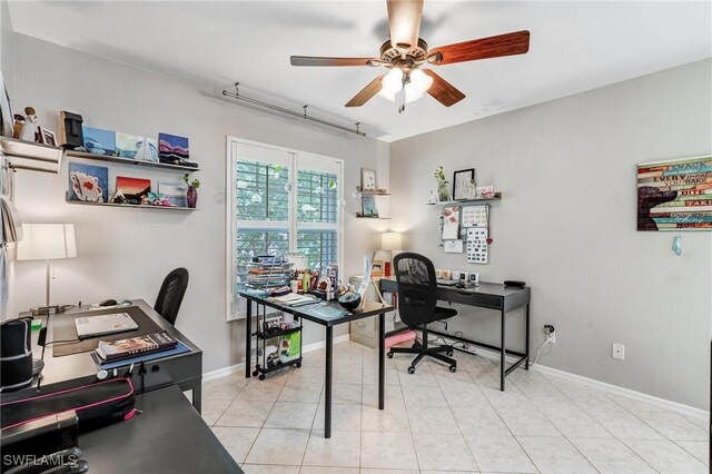 home office with a ceiling fan, baseboards, and light tile patterned flooring