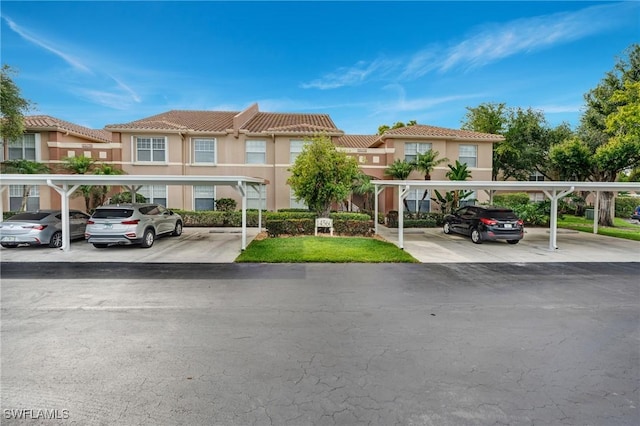 view of property featuring covered parking, stucco siding, and a tiled roof