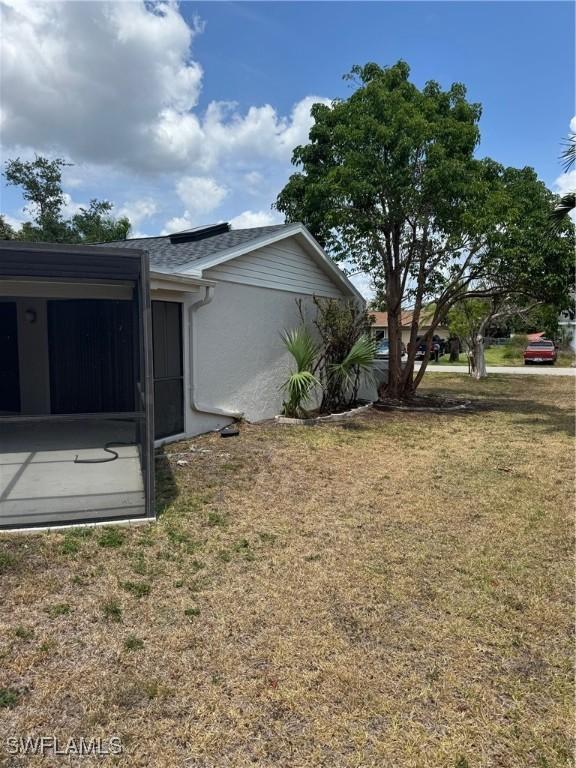 view of property exterior featuring a lawn and stucco siding